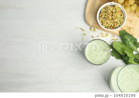 Flat lay composition with green buckwheat smoothie on white wooden table, space for text Flat lay composition with green buckwheat smoothie on white wooden table, space for text 104810198
