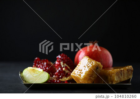 Honey, apples and pomegranate on dark table. Rosh Hashanah holiday Honey, apples and pomegranate on dark table. Rosh Hashanah holiday 104810260