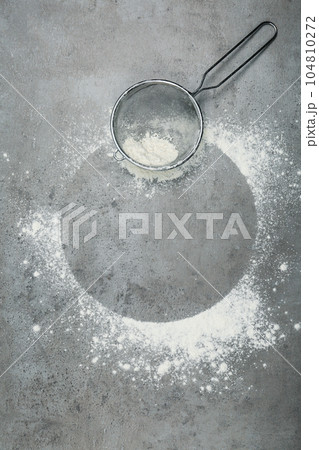Flour and strainer on light grey table, top view. Space for text Flour and strainer on light grey table, top view. Space for text 104810272