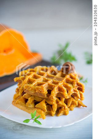 sweet baked pumpkin waffles with honey in a plate 104810630