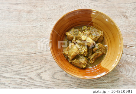 spicy fried pork bone with herb in curry sauce on bowl spicy fried pork bone with herb in curry sauce on bowl 104810991