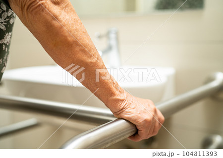 Asian elderly woman patient use toilet bathroom handle security in nursing hospital, healthy strong medical concept. 104811393