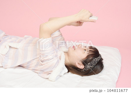 パジャマ姿でスマホを操作する女性 104811677