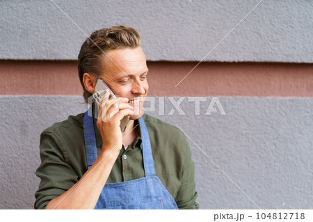 Restaurant worker receive call from client on mobile phone. With focus on communication and customer service, worker exemplifies dedication and multitasking abilities required in restaurant industry Restaurant worker receive call from client on mobile phone. With focus on communication and customer service, worker exemplifies dedication and multitasking abilities required in restaurant industry 104812718