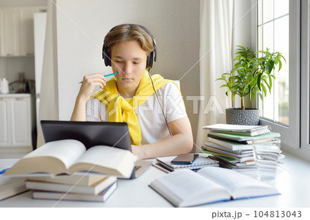 Teenager boy study at home. Online education and distance learning for children. School boy doing his physics homework using gadgets. Lessons on the internet for high school students 104813043