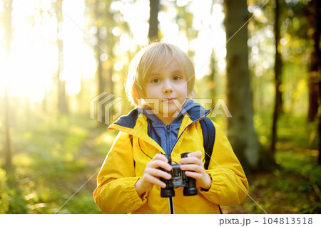 Little boy scout with binoculars during hiking in autumn forest. Child is looking with binoculars. Exploring nature Little boy scout with binoculars during hiking in autumn forest. Child is looking with binoculars. Exploring nature 104813518