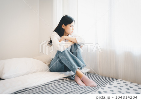 Young attractive asian woman lying at home living room couch feeling sad tired and worried suffering depression in mental health, problems and broken heart concept 104814204