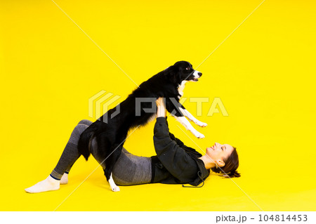 Woman walking and getting exercise for both herself and her border collie dog. Woman walking and getting exercise for both herself and her border collie dog. 104814453