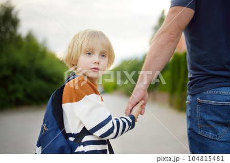 Little schoolboy with his father goes to school after summer holiday. Parent accompanies his scared child. Kids fears. Quality education for children. Back to school 104815481