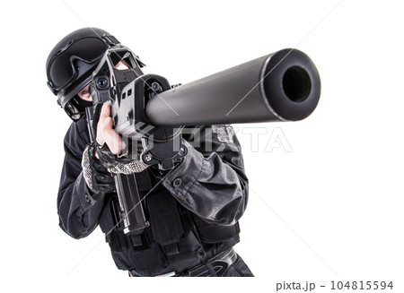 Spec ops police officer SWAT in black uniform aiming service rifle, studio shot 104815594