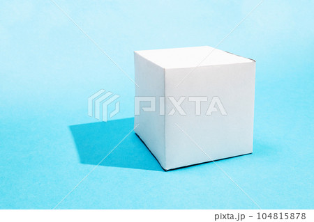 one hand-crafted paper cube on turquoise blue 104815878