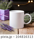 Coffee mug, a white cup on a table with lavender flowers. Styled photo, product mockup 104816313