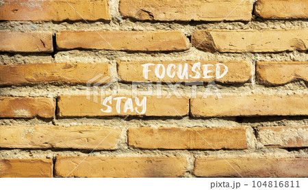 Stay focused symbol. Concept words Stay focused on beautiful brown bricks on a beautiful brick wall background. Business, support, motivation, psychological and stay focused concept. Copy space. 104816811