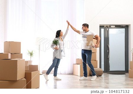 Happy couple in room with cardboard boxes on moving day 104817132