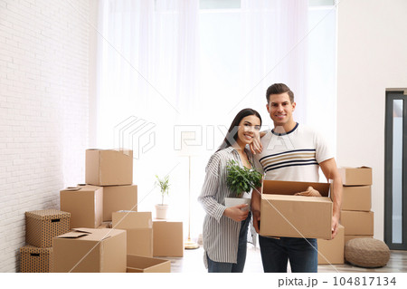 Happy couple in room with cardboard boxes on moving day 104817134