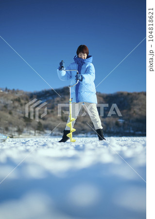 凍った湖に穴をあける20代女性 104818621