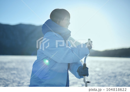 凍った湖に穴をあける20代女性 104818622
