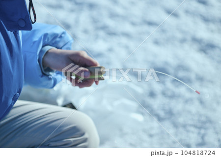 冬の湖でワカサギ釣りをする20代女性 104818724