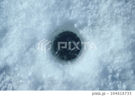 ワカサギ釣りのために氷上に開けられた穴 104818735