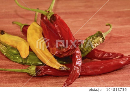 Shrinking and mould chili peppers on red wooden background. Rotten chili peppers Shrinking and mould chili peppers on red wooden background. Rotten chili peppers 104818756