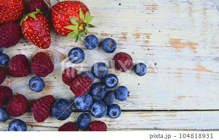 Healthy mixed fruit and ingredients with strawberry, raspberry, blueberry from top view. Berries on rustic white wooden background. Flat design. Free space for text. Copy space for banner Healthy mixed fruit and ingredients with strawberry, raspberry, blueberry from top view. Berries on rustic white wooden background. Flat design. Free space for text. Copy space for banner 104818931