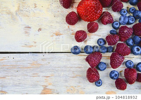 Healthy mixed fruit and ingredients with strawberry, raspberry, blueberry from top view. Berries on rustic white wooden background. Flat design. Free space for text. Copy space for banner Healthy mixed fruit and ingredients with strawberry, raspberry, blueberry from top view. Berries on rustic white wooden background. Flat design. Free space for text. Copy space for banner 104818932
