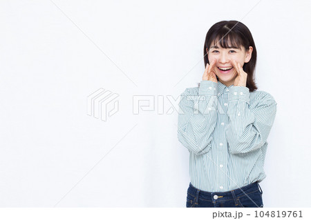 白い背景の前で笑顔で叫んでいる30代の女性 白い背景の前で笑顔で叫んでいる30代の女性 104819761