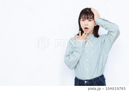 白い背景の前でビックリしている30代の女性 104819765