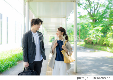 屋外を歩く男女オフィスカジュアル 104820977