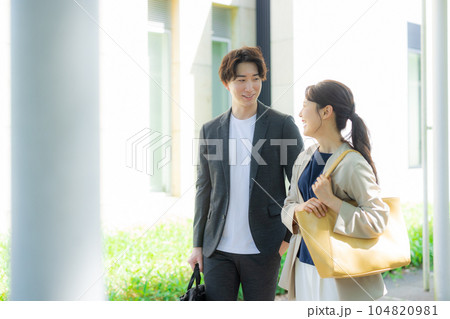 屋外を歩く男女オフィスカジュアル 104820981