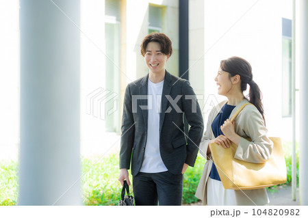 屋外を歩く男女オフィスカジュアル 104820982