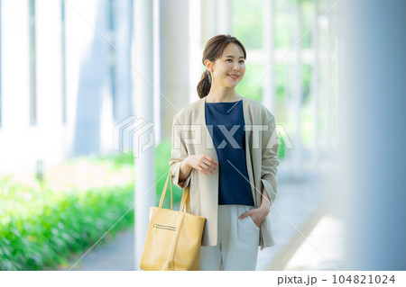 屋外を歩くオフィスカジュアルの女性 104821024