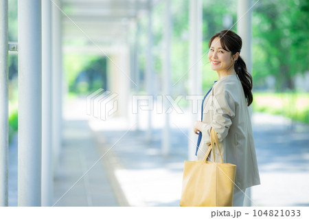 屋外を歩くオフィスカジュアルの女性 104821033