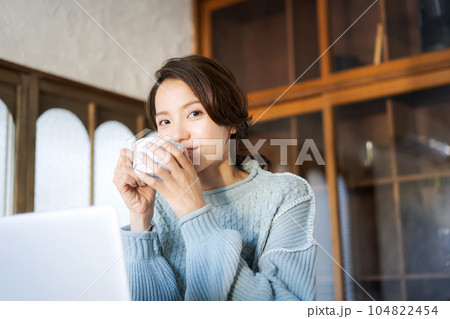 コーヒーを飲みながらパソコンを見る女性 コーヒーを飲みながらパソコンを見る女性 104822454