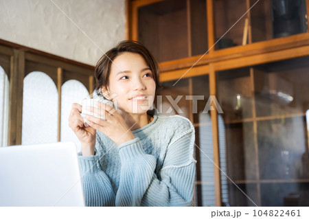 コーヒーを飲みながらパソコンを見る女性 コーヒーを飲みながらパソコンを見る女性 104822461