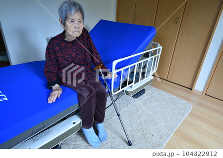 介護ベッドに座るシニア女性 介護ベッドに座るシニア女性 104822912