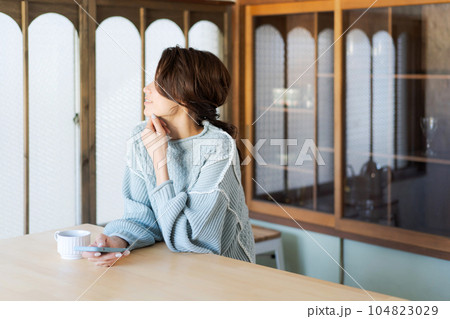 スマホを見るニットを着た女性の写真 スマホを見るニットを着た女性の写真 104823029