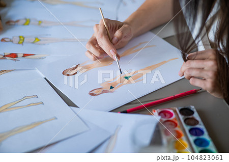 Faceless woman draws sketches of swimwear. Close-up of the hands of a fashion designer. 104823061