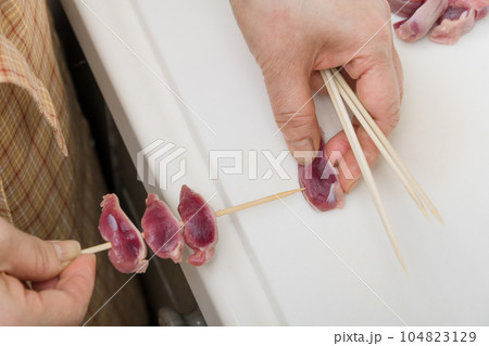 【焼き鳥砂肝の串打ちをする主婦】 104823129