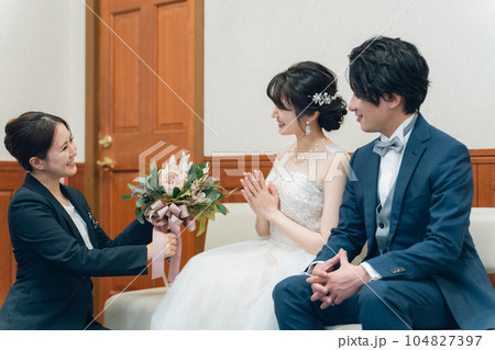 結婚式場のブライズルーム・控室で花束・ブーケを持つ新郎新婦の男女(ドレス試着・衣装合わせ) 結婚式場のブライズルーム・控室で花束・ブーケを持つ新郎新婦の男女(ドレス試着・衣装合わせ) 104827397