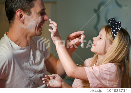 Father and daughter soil each other with flour Father and daughter soil each other with flour 104828734