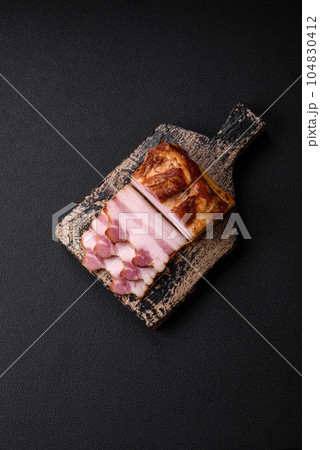 Delicious calorie smoked bacon with salt, spices and herbs Delicious calorie smoked bacon with salt, spices and herbs 104830412