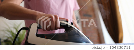 Happy housewife ironing clothes at home. Happy housewife ironing clothes at home. 104830711