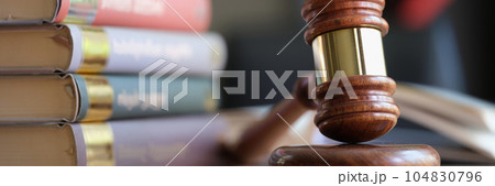 Wooden judge gavel and stack of legal book on table. Wooden judge gavel and stack of legal book on table. 104830796