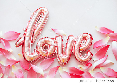 Flowery petals and word Love from foil balloon, creative layout. 104831539
