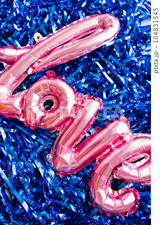 Word Love from foil balloon against tinsel. Valentines day party concept. Word Love from foil balloon against tinsel. Valentines day party concept. 104831545