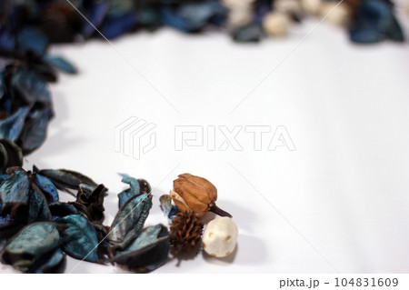 A mix of dry flowers, leaves, petals, and other plant parts. Potpourri background. Purple and blue tone leaves, white color and wood grain background shot. A mix of dry flowers, leaves, petals, and other plant parts. Potpourri background. Purple and blue tone leaves, white color and wood grain background shot. 104831609