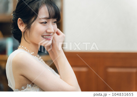 結婚式・挙式・披露宴の支度をするイヤリング・ブライダルジュエリーをつける新婦・花嫁の女性 結婚式・挙式・披露宴の支度をするイヤリング・ブライダルジュエリーをつける新婦・花嫁の女性 104831655
