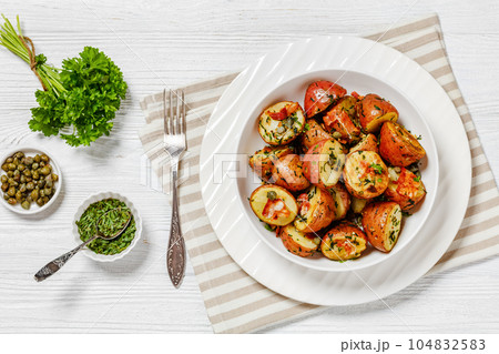Herbs Garlic Potatoes in white bowl, top view Herbs Garlic Potatoes in white bowl, top view 104832583
