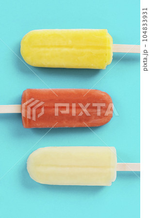 水色背景上の棒つきアイスキャンディのクローズアップ 104833931